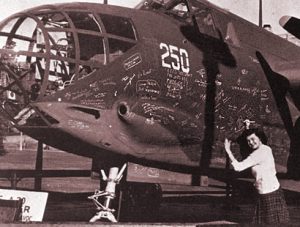 Students autograph a Douglas bomber A-20 displayed on campus between the men’s and women's gyms