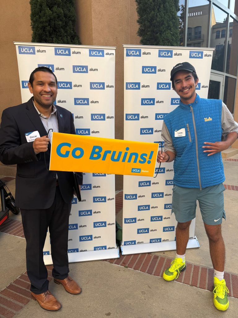 Mentor and student holding Go Bruins! banner