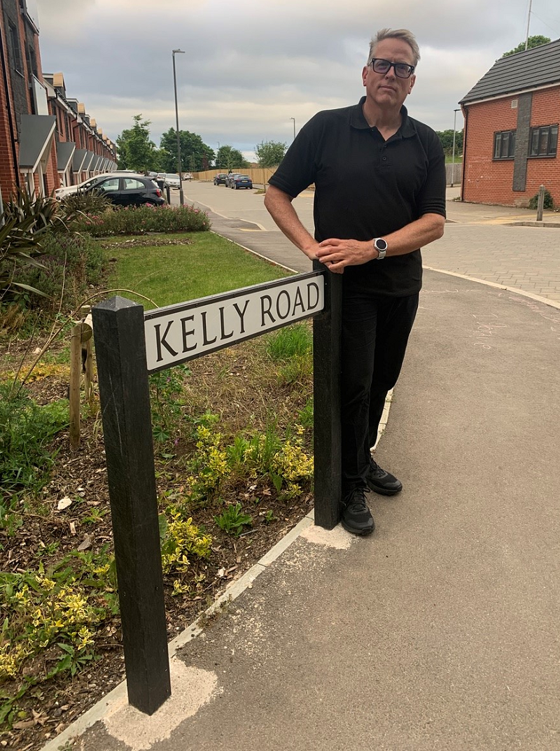 Jesse Kelly, the youngest son of Martha Gail Kelly '54, at one of the road signs for Kelly Road, which has been named after her.