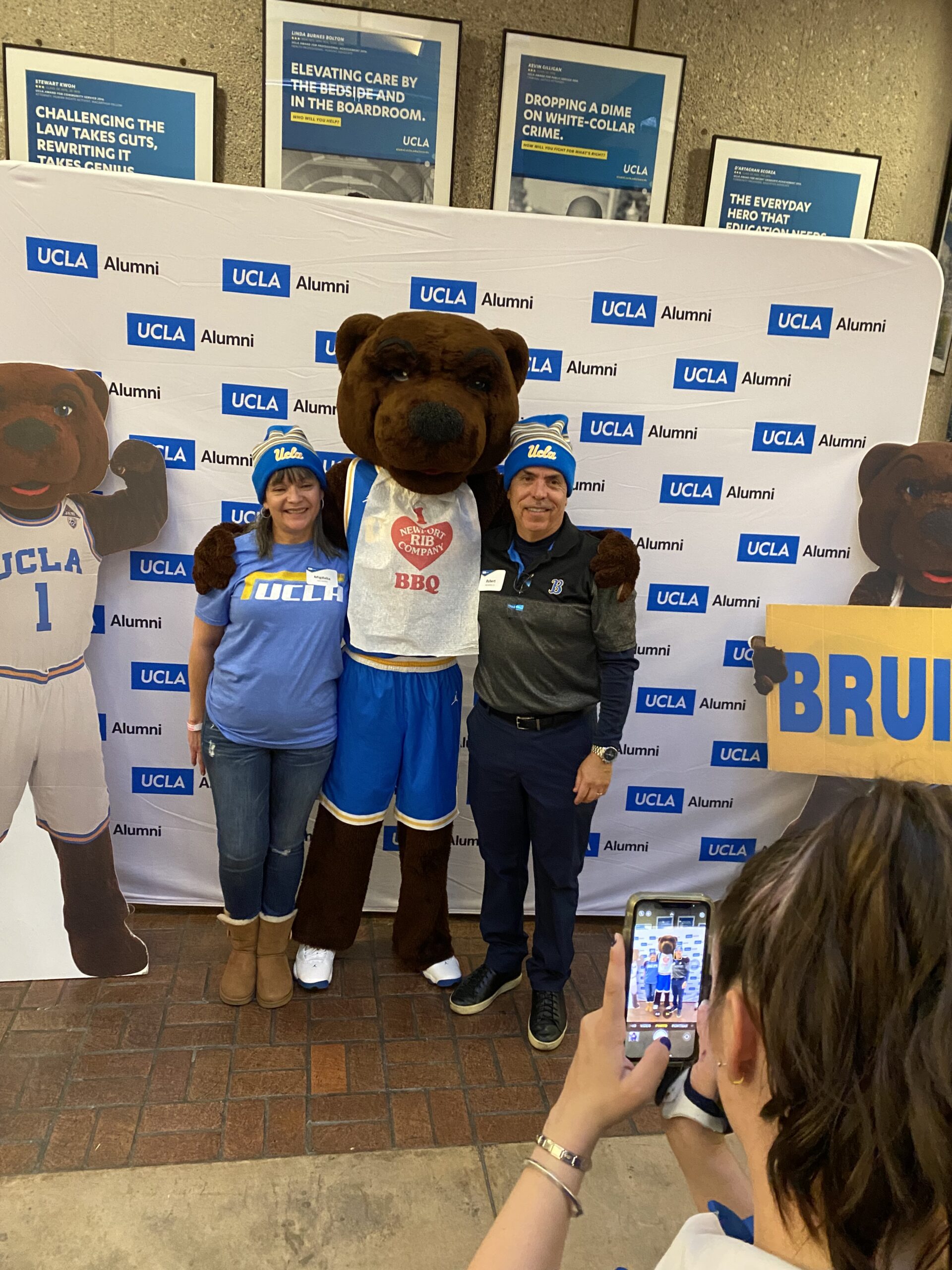 Attendees taking photos with Joe Bruin at the men's basketball Bruin Bash (03/04/23).