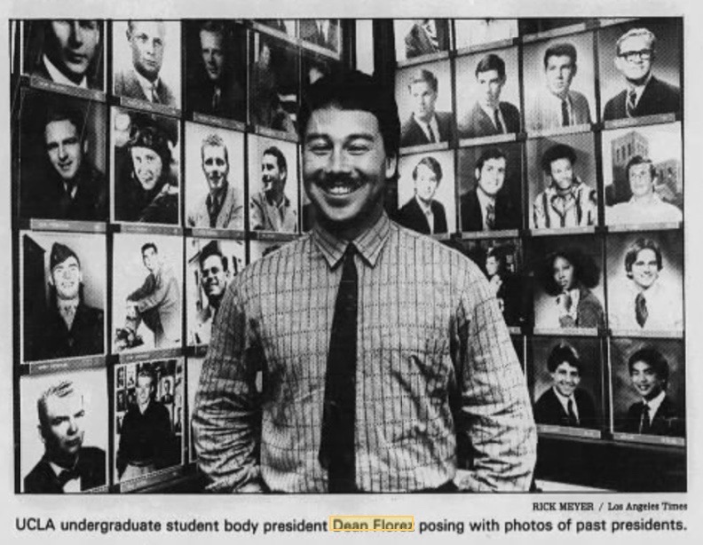 Dean Flores posing in front a wall covered in photos of past student presidents