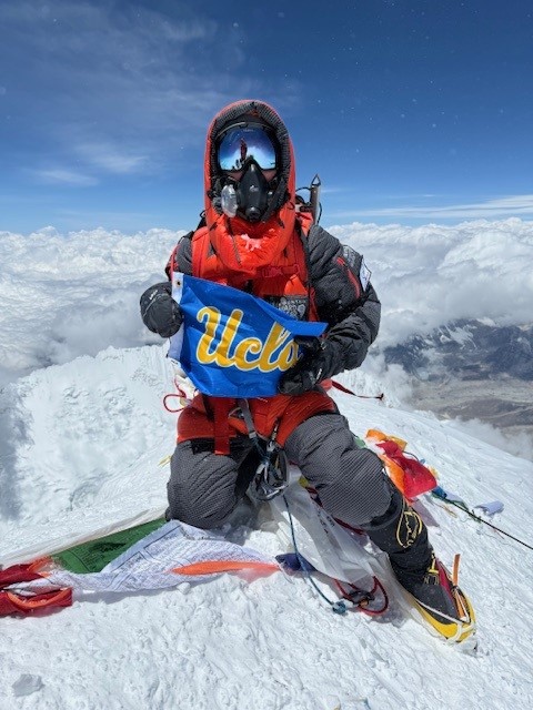 Dean Poulakidas with UCLA banner at summit of Mount Everest